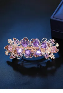 Rhinestone hair clip detail showing sparkling purple crystals and elegant metal flower spring design.