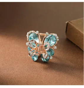 Detailaufnahme einer eleganten Schmetterling Haarklammer mit blauen Strasssteinen in Roségold.