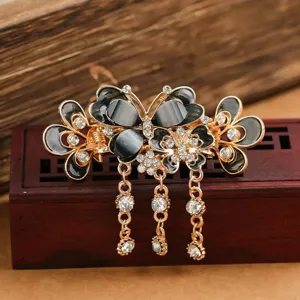 Detail shot of retro butterfly hair claw clip with sparkly rhinestones and dangling tassels.
