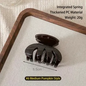 Detail shot of a dark brown pumpkin hair claw clip, featuring thick PC material and 6.5cm size.