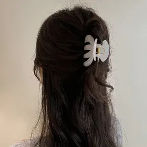 Minimalist white hair claw clip for women, stylish hollow shark clip for elegant updos.