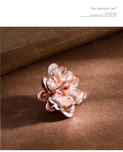 Metal flower hair claw clip detail view, rose gold finish, elegant small daisy design.