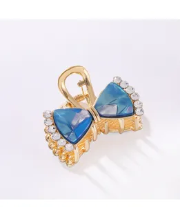 Dettagli in primo piano dell'elegante molletta per capelli a fiocco blu con strass lucidi.