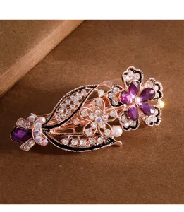Detailed view of a gorgeous rose gold crystal hair clip featuring purple rhinestones and pearls.