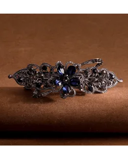 Vintage crystal hair clip featuring blue rhinestones and an intricate floral metal design.