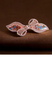 Elegant rhinestone bow hair clip with colorful crystals, rose gold tone spring barrette detail shot.