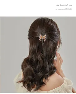 Close-up of a stylish alloy butterfly hair claw clip with rhinestones for elegant styling.