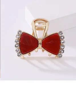 Vista dettagliata del fermaglio per capelli con fiocco in acetato e strass, elegante accessorio.