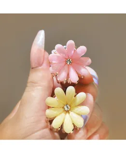 Detail view of small flower hair claw clips with sparkling rhinestones, alloy base.