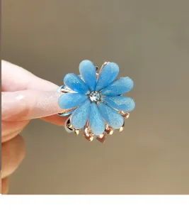 Close-up detail of blue flower hair claw clip with sparkly rhinestones and alloy base.