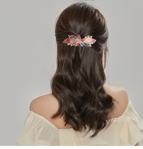 Detailed view of large rhinestone flower hair clip worn elegantly on dark hair for chic hairstyles.