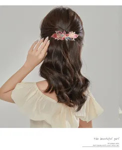 Detailed view of the sparkling rhinestone hair clip worn on elegant dark hair, showing leaf design.
