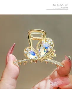 Close-up detail of luxury crystal butterfly hair claw clip, sparkling rhinestones, gold.