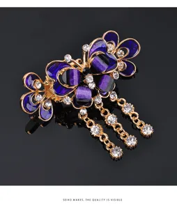 Close-up detail of elegant butterfly hair claw clip with purple pattern and sparkling rhinestones.