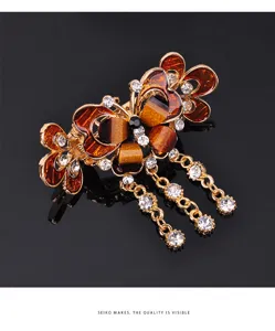 Close-up of elegant butterfly hair claw clip with sparkling rhinestones and hanging crystal tassels.