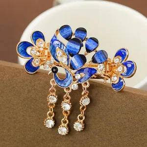 Détail de la pince griffe de cheveux paon rétro strass bleu et pompons en cristal brillants.