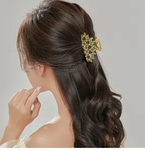 Detailed view of a vintage gold metal flower hair claw clip styling elegant updos securely.
