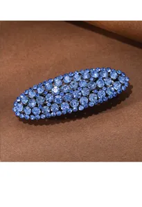 Close-up detail of blue rhinestone hair barrette, sparkling crystal clip for elegant styling.