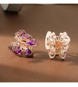 Close-up detail of exquisite butterfly hair claws featuring sparkling purple rhinestones pearls.