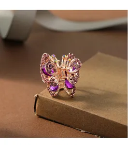 Close-up detail of a sparkling rhinestone butterfly hair claw clip with purple crystals.