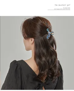 Blue rhinestone bow hair claw clip for women, elegant metal jaw clip for styling hair.