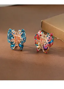Detailed close-up of rhinestone butterfly hair claw clips, shining alloy metal accessories.