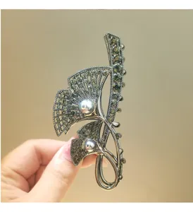 Close-up detail of the metal ginkgo leaf hair claw clip with sparkling rhinestones.