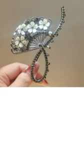 Exquisite fan-shaped hair claw clip featuring sparkling rhinestones and elegant white flowers.