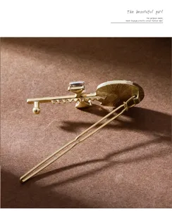 Gold lollipop hairpin detail shot, sweet rhinestone and pearl design for stylish side hair styling.