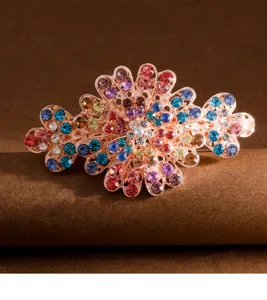 Nahaufnahme Detailansicht einer bunten Strass Metall Federhaarklammer mit glitzernden Kristallen.
