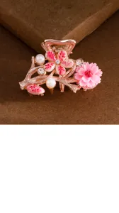 Close-up detail of a pink floral hair claw clip, featuring rhinestone and resin flower design.