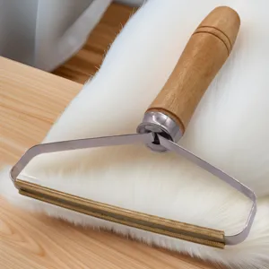 Hondenhaar en kattenhaar verwijderaar met houten handvat en metalen schraper voor tapijt.