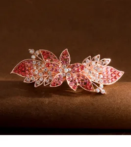 Close-up detail of the elegant floral rhinestone hair clip with sparkling pink and clear crystals.