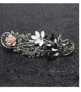 Vintage rhinestone hair clip detail, retro metal barrette with flower and crystal accents.