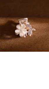 Petite pince à cheveux métallique élégante avec fleur blanche et strass pour coiffure quotidienne.