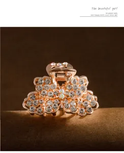 Closeup of a sparkling rhinestone butterfly hair claw clip with rose gold metal finish.