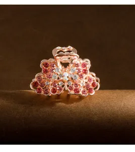 Close-up detail of a mini rose gold rhinestone flower claw clip, elegant hair accessory.