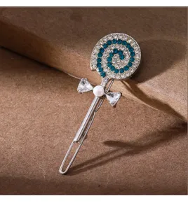 Close-up detail of a sparkling rhinestone lollipop hairpin with blue crystals and pearls.