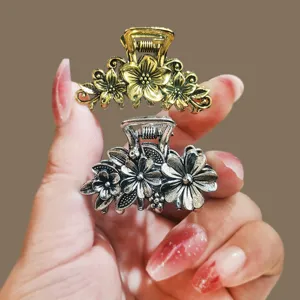 Gold silver metallic flower hair claws held in hand, elegant mini hair clips for women