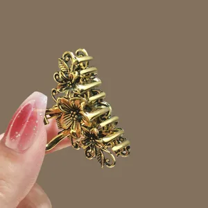 Retro gold metal hair claw clip with elegant floral design, simple and chic for women styling.
