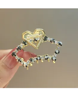 Golden metal rhinestone heart hair claw clip detail view, elegant hair accessory for women.