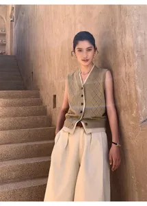 Women contrast V-neck argyle hollow knit vest paired with chic cream wide-leg pants.