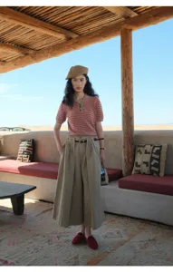 Detailed view of the stylish striped knit short-sleeve top paired with wide-leg trousers.