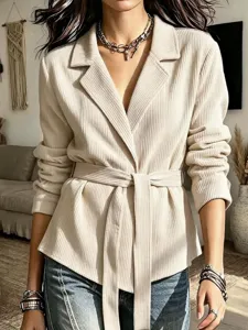 Detailed view of women's beige corduroy blazer jacket with belt and lapel collar style.
