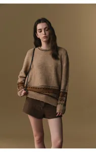 Detailed view of women's autumn winter knit sweater and tweed shorts outfit in chic brown tone.