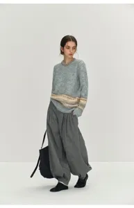 Stylish wool blend high waist pleated harem pants featuring relaxed fit and elegant drape.