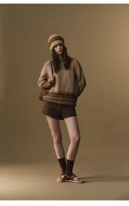 Detailed view of the women's high-waisted woolen shorts styled with knitwear in a cozy outfit.