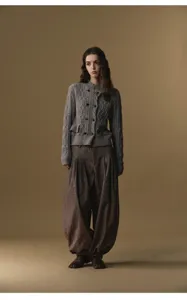 Detail view of pleated harem pants outfit with knit cardigan and split toe shoes.