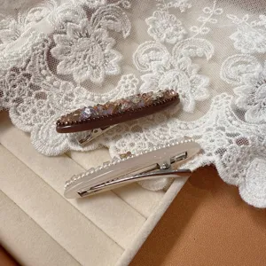 Detailaufnahme von Kristall-Haarspangen, elegante Acetat-Haarnadel mit glitzernden Strasssteinen.