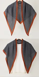 Foulard triangulaire pied-de-poule classique avec bord orange, détail châle léger.